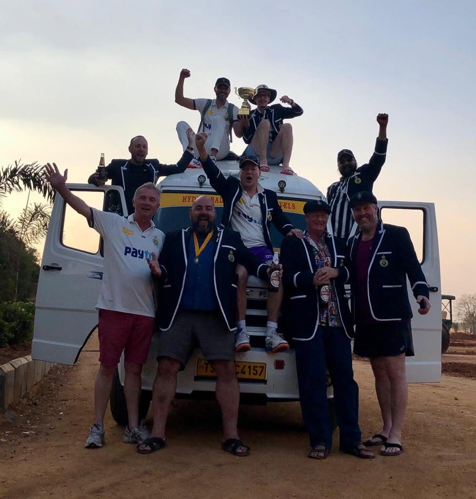 Touring cricket side celebrating with a trophy on their tour bus in Hyderabad, India